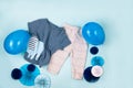 Set of warm baby clothes with bodysuits for boy on blue background. Collection of cute baby clothes. Gift for the birth of a boy