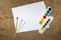 Set of watercolor paints, brushes for painting and blank white paper sheet of sketchbook. Royalty Free Stock Photo