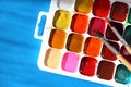 Set of watercolor paints with dirty brushes on blue background. Royalty Free Stock Photo