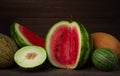 Set of watermelons and melons, several types, sliced, on a wooden background, horizontal, no people,