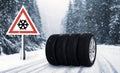 Set of wheels with winter tires and road sign outdoors