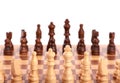 Set of white and black wooden chess pieces standing on a chessboard,  on white background Royalty Free Stock Photo