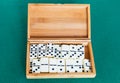 Set of white dominoes tiles in bamboo box on table Royalty Free Stock Photo