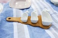 Set of white empty sauceboats on a wooden tray serves a picnic