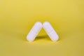 Set of white pills on a yellow background. Royalty Free Stock Photo