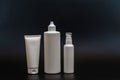 Set of white plastic bottles packages, tubes on black background. For cosmetic product. For cream, bottle with spray, lotio Royalty Free Stock Photo