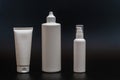 Set of white plastic bottles packages, tubes on black background. For cosmetic product. Royalty Free Stock Photo