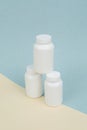 Set of White plastics medicals containers for tablets or capsules on a yellow-blue background Royalty Free Stock Photo