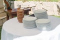 Set of white plates stacked on a table with matel in an outdoor garden