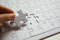 Set of white puzzle pieces and hand holding last one piece Royalty Free Stock Photo