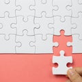 Set of white puzzle pieces and hand holding last one piece Royalty Free Stock Photo