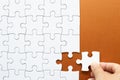 Set of white puzzle pieces and hand holding last one piece Royalty Free Stock Photo