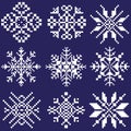 Set of white snowflakes of different shapes on a blue background drawn by squares, pixels. An element of ornament in the design Royalty Free Stock Photo