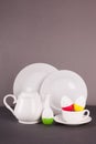 Set of white utensils for Easter tea drinking and decorative cheerful eggs. Spring home concept.