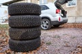 Set of winter wheels and tyres ready for changing near car, copyspace Royalty Free Stock Photo