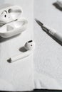 A set of wireless earbuds, charging cases, and cleaning tools laid out on a white surface during a detailed cleaning Royalty Free Stock Photo
