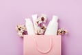 Set of woman`s cosmetics in a bag with spring apricot bloom.