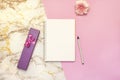 Set of women`s accessories desk - notebook with pen, pink box gifts, flower on pink marble background. Workspace table for beauty Royalty Free Stock Photo