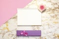 Set of women`s accessories desk - notebook, pink box gifts, flower on pink marble background. Workspace table for beauty blogger Royalty Free Stock Photo