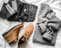 Set of women`s autumn, winter clothes on a light background - jeans, gray pullover oversize, suede brown boots and scarf. Fashion