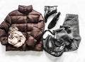 Set of women`s autumn, winter clothing - down jacket, black leather shoes, gray jeans, cashmere scarf, bag on a light background, Royalty Free Stock Photo