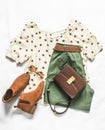 Set of women`s summer clothes - bermuda shorts, polka dot blouse, chelsea boots and cross body bag on a light background, top