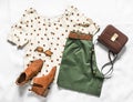 Set of women`s summer clothes - bermuda shorts, polka dot blouse, chelsea boots and cross body bag on a light background, top