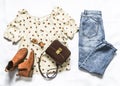 Set of women`s summer clothes - blue mom jeans, polka dot blouse, chelsea boots and cross body bag on a light background, top