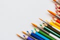 Set of wooden colored pencils- crayons and watercolor brushes on a white paper. Top view Royalty Free Stock Photo