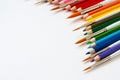 Set of wooden colored pencils- crayons and watercolor brushes on a white paper. Top view. Copy space Royalty Free Stock Photo