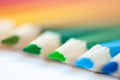 Set of wooden colored pencils- crayons on a white paper. Close up. Selective focus Royalty Free Stock Photo