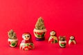A set of wooden dolls nesting dolls on a red background, they contain dry buds of medical marijuana.