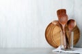 Set of wooden kitchen utensils and plates on light grey table. Space for text Royalty Free Stock Photo