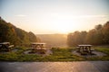 Set of wooden picnic tables with a stunning view of a sunrise in a tranquil forest setting