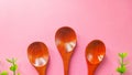 Set of wooden spoon three-piece and green plastic leaf isolated on pink background. Concept: kitchen utensils made from natural Royalty Free Stock Photo