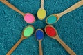 Set of wooden spoons with colored sand on blue stones Royalty Free Stock Photo