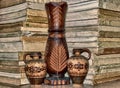 Set of wooden vase and cups on a shelf with old books