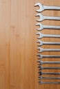 A set of working tools, different size wrenches on a brown wooden, bamboo background Royalty Free Stock Photo