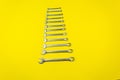 Set of wrenches of different sizes on a yellow background