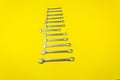 Set of wrenches of different sizes on a yellow background