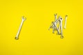 Set of wrenches of different sizes on a yellow background