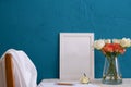 Set for writing, a bouquet of roses in a vase and a white photo frame on a blue background Royalty Free Stock Photo