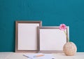 Set for writing, pink gerbera flower in an old vase, two gray frames for a photo on a blue background Royalty Free Stock Photo