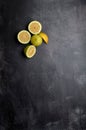 yellow and green lemons, cut and uncut, on a background of dark, black, cement, metallic, marble and stone Royalty Free Stock Photo