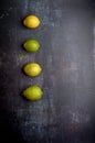 yellow and green lemons on a dark, black, cement, metallic, marble and stone background Royalty Free Stock Photo