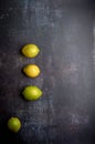 yellow and green lemons on a dark, black, cement, metallic, marble and stone background Royalty Free Stock Photo