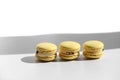 Set of yellow macaroons or macarons with shadow from window isolated on white background. Seamless pattern. Delicious healthy