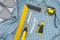 Set of yellow tools on checkered shirt and sneakers top view. men`s hobby flat lay concept Royalty Free Stock Photo