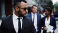 Set your own trends in the business world. a handsome young businessman walking in the city with his colleagues behind Royalty Free Stock Photo