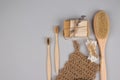 Set of zero waste bathroom essentials on grey background - bamboo toothbrushes, cotton buds, wooden body brush, jute washcloth and Royalty Free Stock Photo